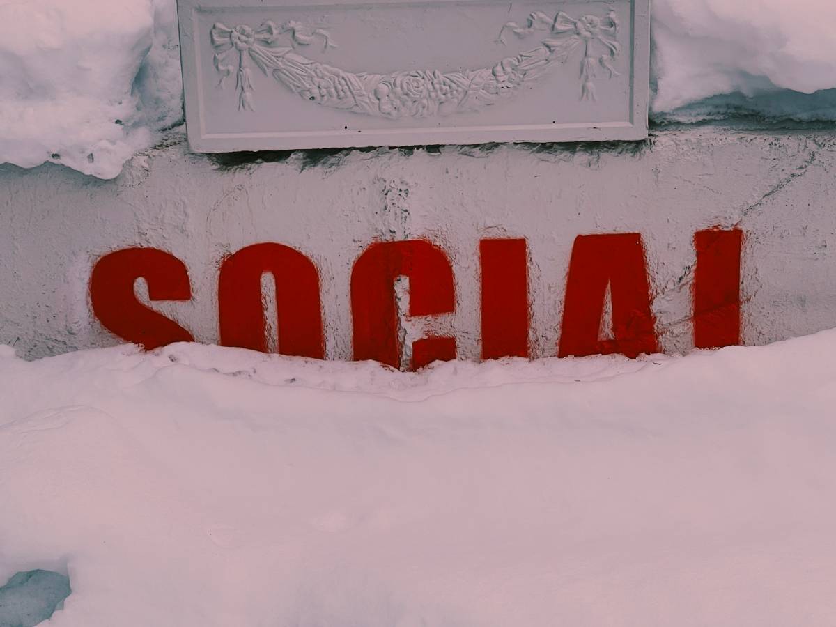 zdjęcie czerwonego napisu SOCIAL na murze, dolna połowa zakryta śniegiem